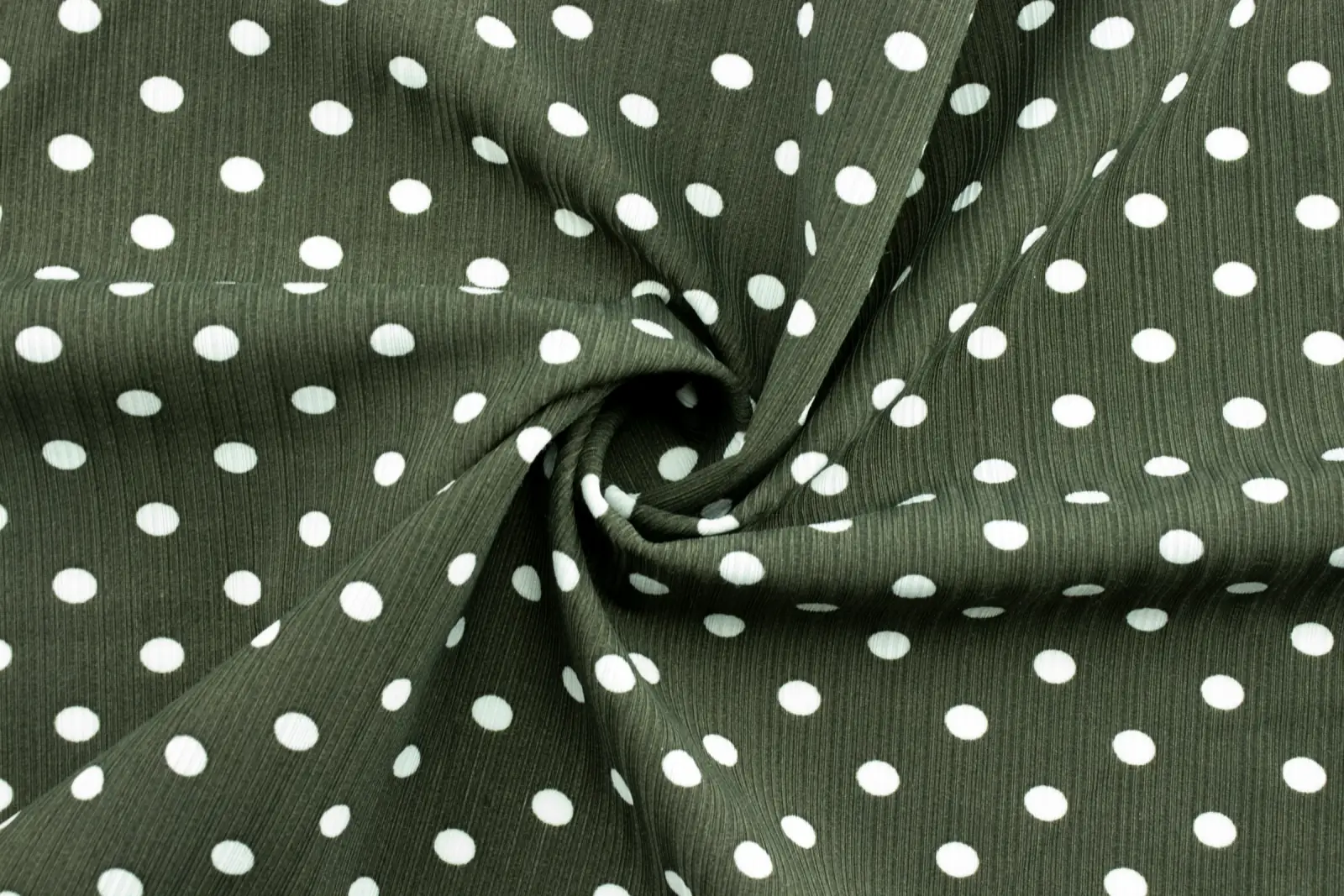 A swirl of dark olive fabric printed with evenly spaced white polka dots