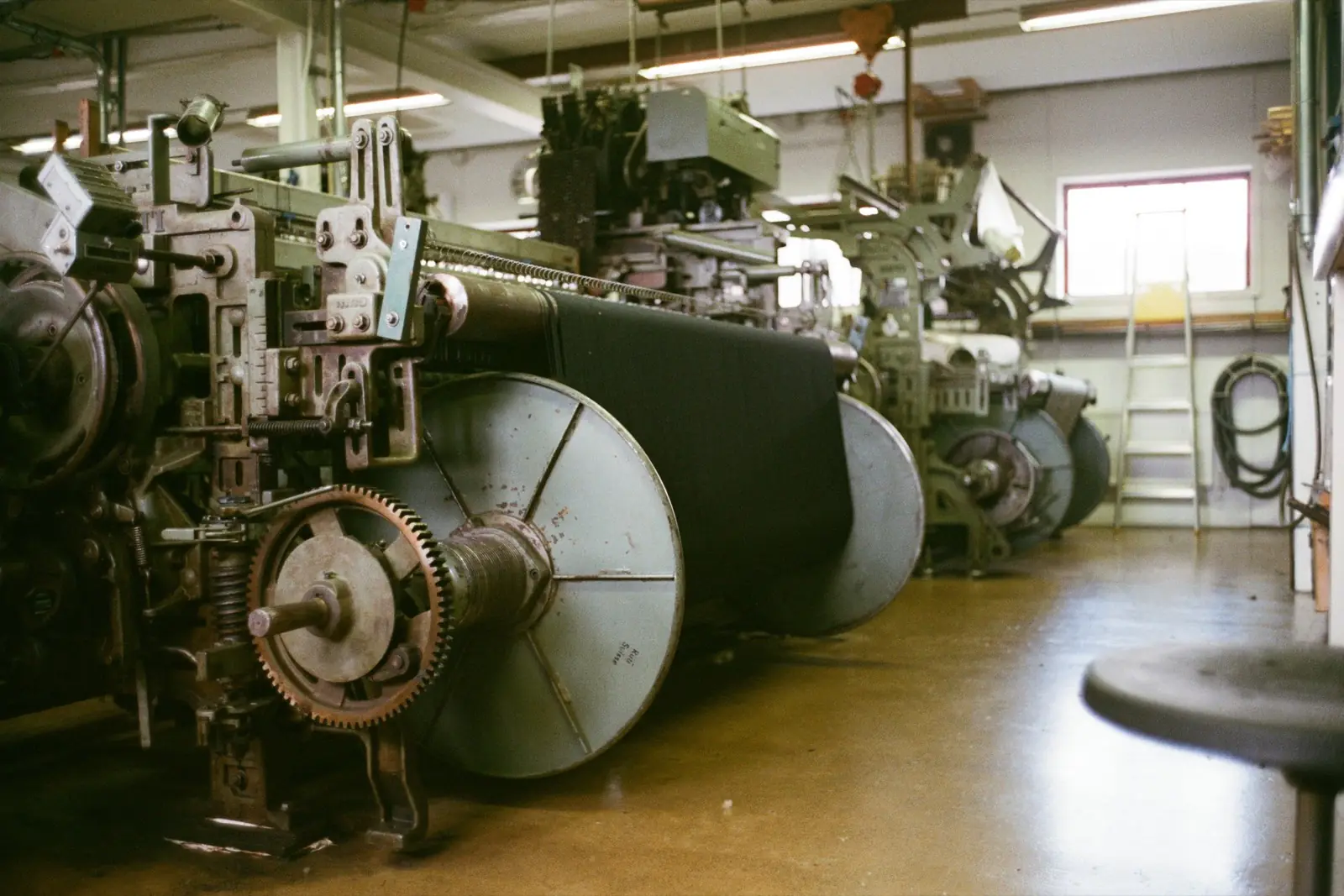 Industrial looms with large warp beams in a weaving shed