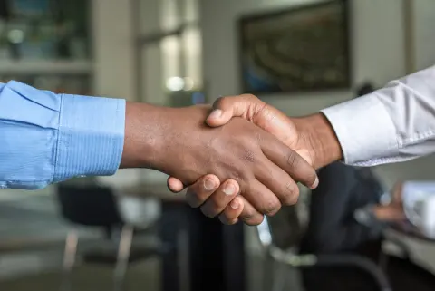 Shopkeeper shaking hands with a customer